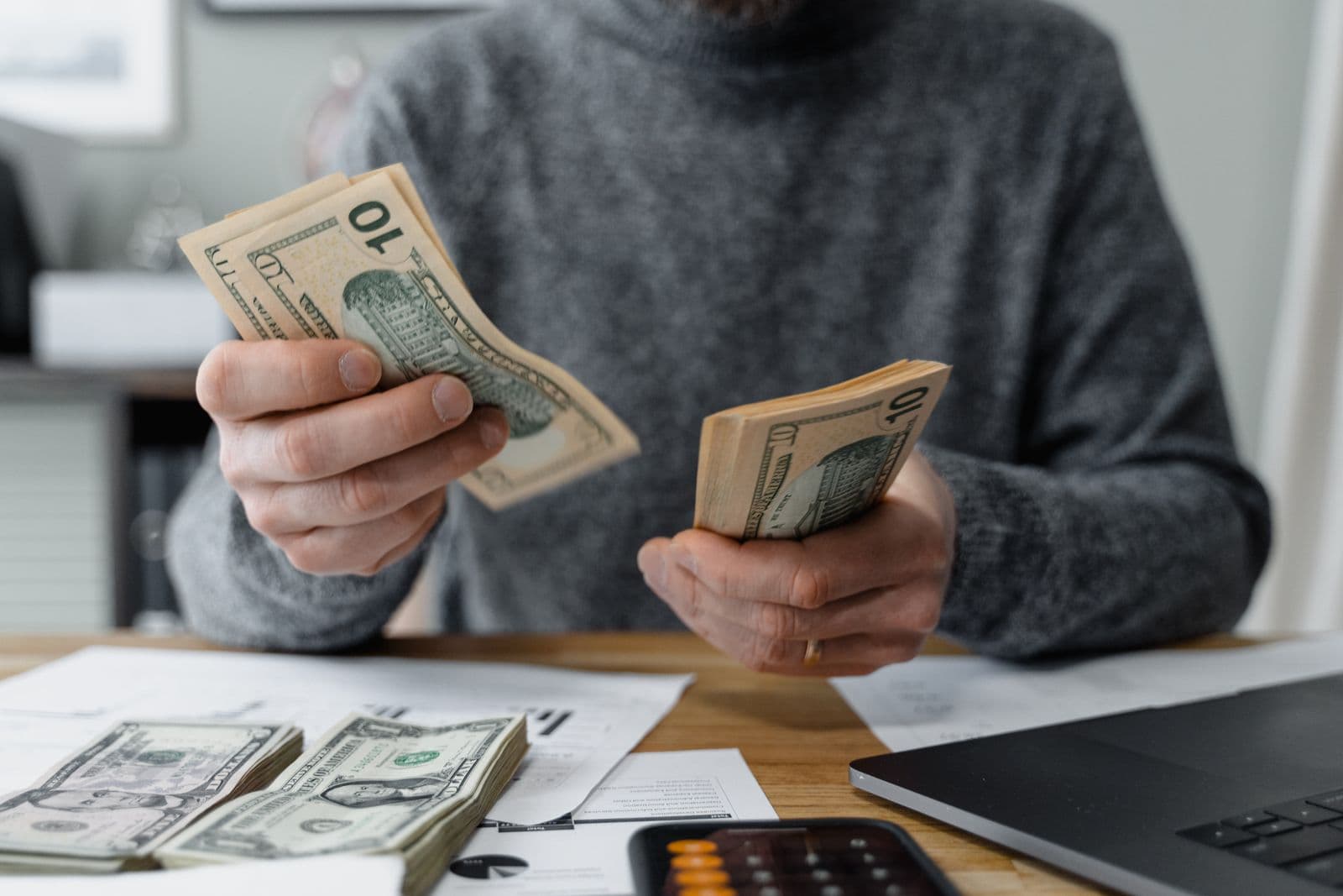 Cash being counted against receipts at a desk