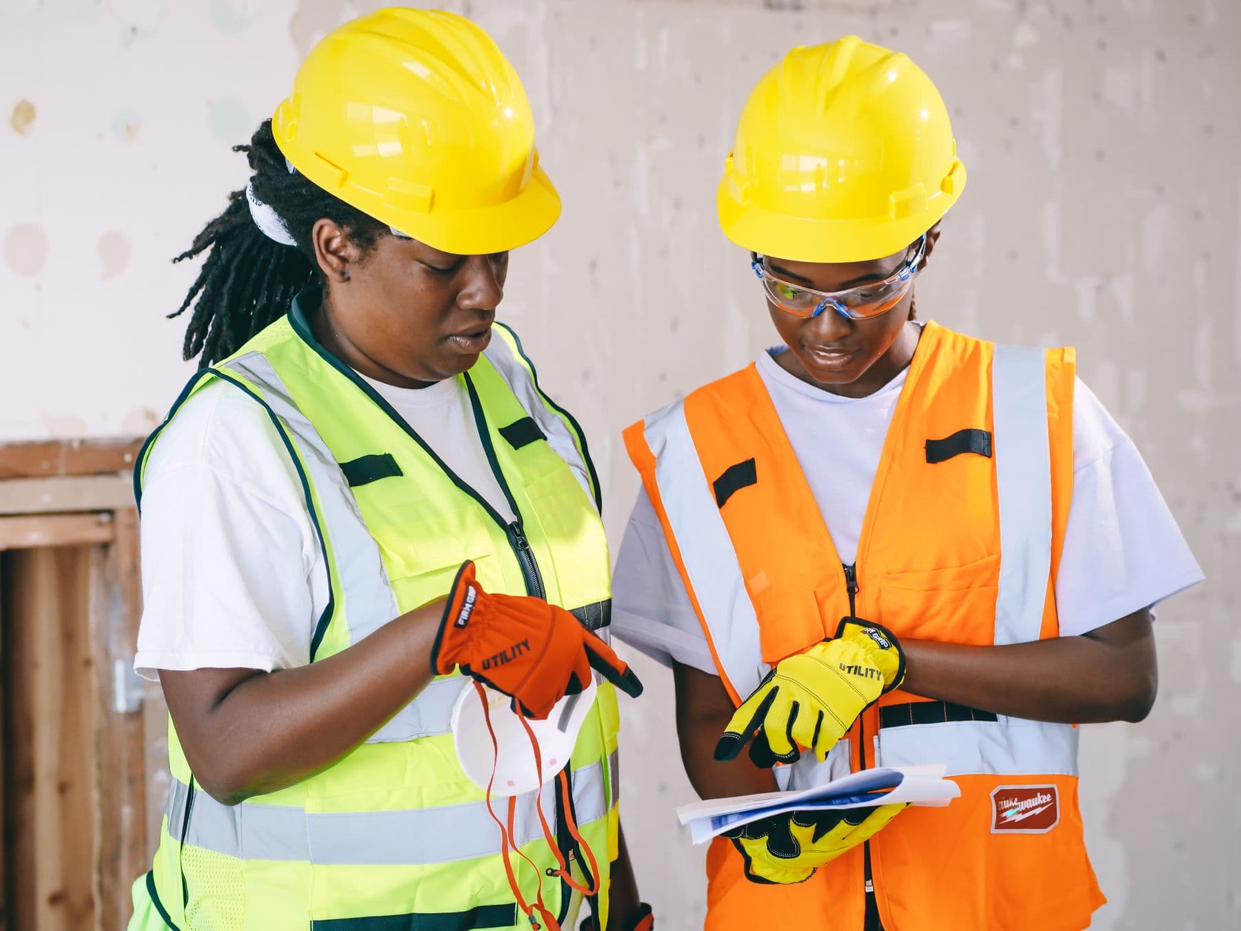 Two site supervisors reviewing job records on a clipboard