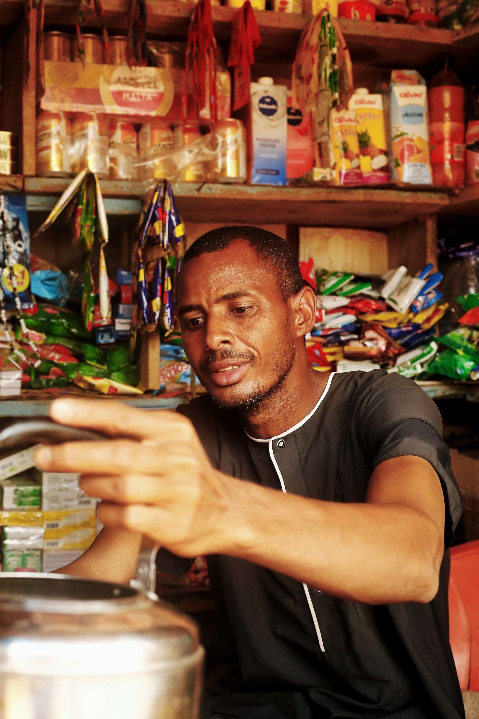 Shopkeeper arranging stock and counting takings in a small store